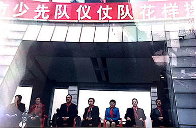 2002年12月14日，東莞市少年先鋒隊第六次代表大會上，廣東省政協常委、東莞時富花園董事長朱正賢先生(右二)與東莞人大等領導一起觀看儀仗隊花樣體操表演